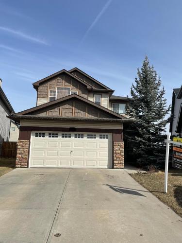 a large house with a white garage door at Sam Estates in Calgary