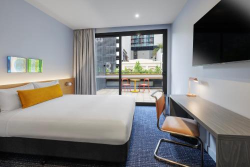 a hotel room with a bed and a large window at lyf on Elizabeth Melbourne in Melbourne