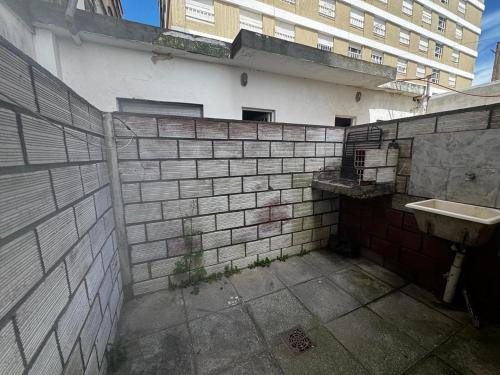 a brick wall with a sink next to a building at Depto 2 ambientes A pasos del MAR in Mar de Ajó
