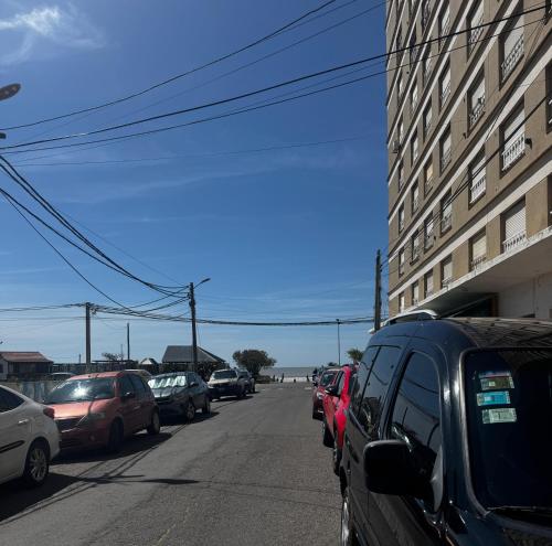 een rij auto's geparkeerd aan de kant van een straat bij Depto 2 ambientes A pasos del MAR in Mar de Ajó