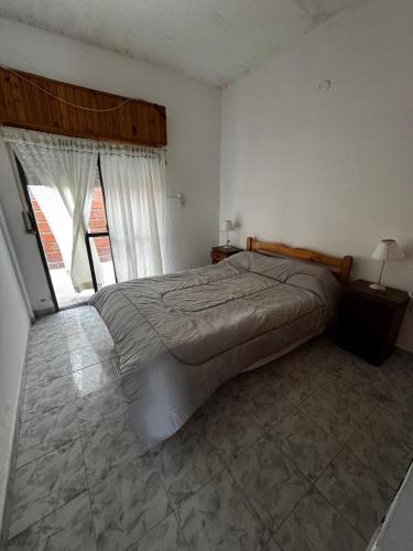 a bedroom with a large bed and a window at Depto 2 ambientes A pasos del MAR in Mar de Ajó