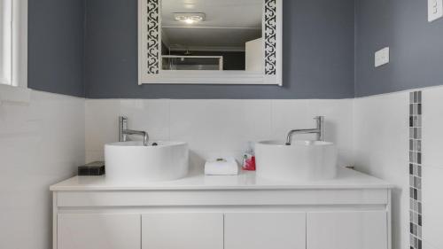 un baño con dos lavabos y un espejo en Coastal Retreat on Hazel, en Kalimna
