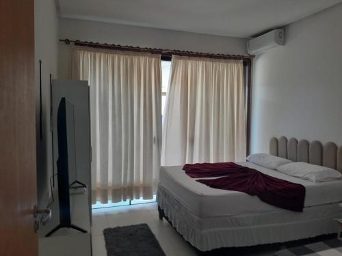 ein Schlafzimmer mit Bett und Flachbildfernseher in der Unterkunft Pousada da Sol na Praia do Frances in Marechal Deodoro