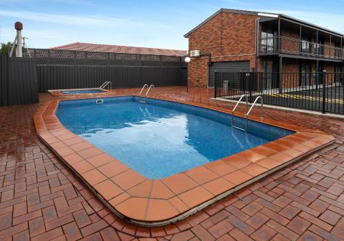 a large swimming pool in a brick yard at Innova Motel Warrnambool in Warrnambool