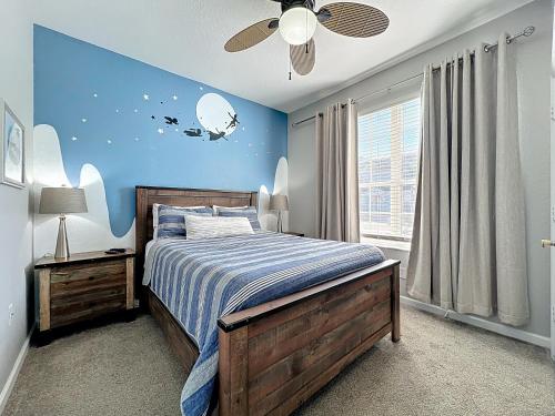 a bedroom with a bed with a blue wall at Private Pool Disney Townhome - Walk to Water Park in Orlando