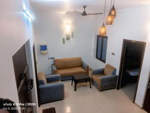 a living room with two chairs and a tv at The Dreams sea view in Puducherry