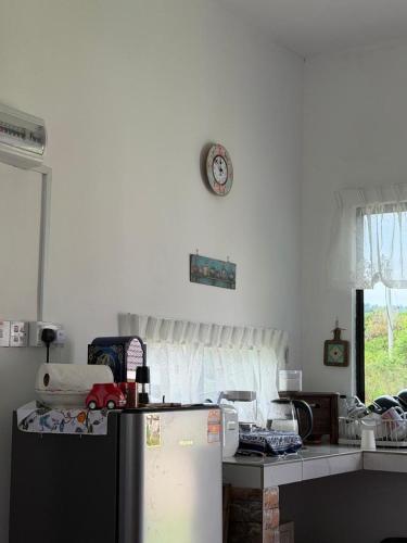 a kitchen with a refrigerator and a clock on the wall at Science and Astronomy Garden in Kampung Dengkil