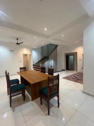 een eetkamer met een tafel en stoelen en een trap bij Mangal Uday Villa in Jaipur