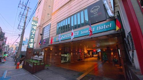 un bâtiment dans une rue de la ville avec un hôtel dans l'établissement Friendly DH Naissance Hotel by Mindrum Group, à Séoul