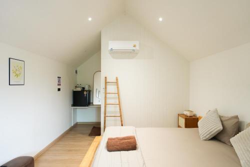 een slaapkamer met een ladder naast een bed bij กู๊ดวิวแคมป์ชะอม in Ban Bung Mai