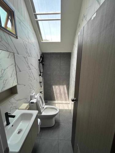 a bathroom with a toilet and a sink and a skylight at กู๊ดวิวแคมป์ชะอม in Ban Bung Mai