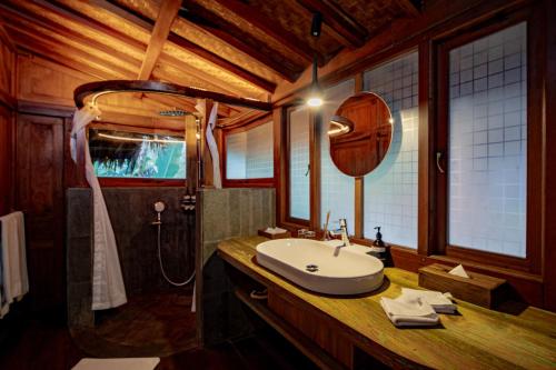 a bathroom with a sink and a mirror on a counter at Tira Vilagna Suites & Spa in Kintamani