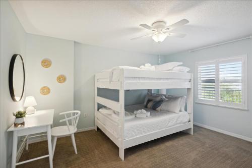 a white bunk bed in a room with a desk at Shorewood 401 in Cape Canaveral