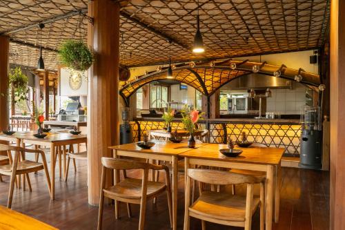 a large kitchen with wooden tables and chairs at Tira Vilagna Suites & Spa in Kintamani