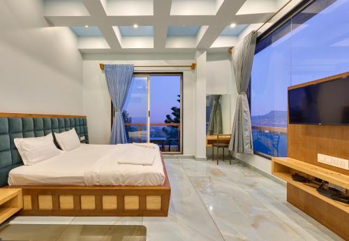 ein Schlafzimmer mit einem Bett und einem großen TV in der Unterkunft Natural resort in Panhāla