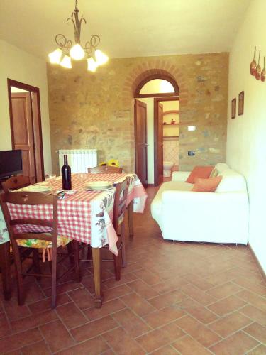 a living room with a table and a couch at Casa ai Carfini in Poggibonsi