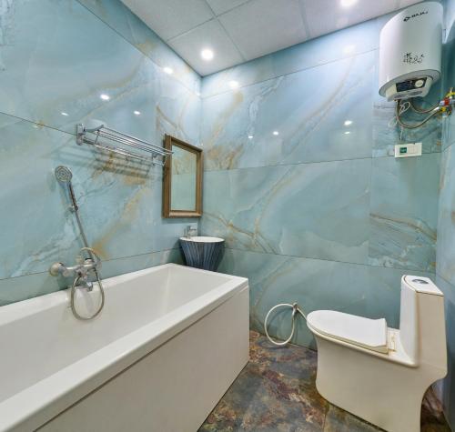 ein Badezimmer mit Badewanne, Waschbecken und Toilette in der Unterkunft Natural resort in Panhāla