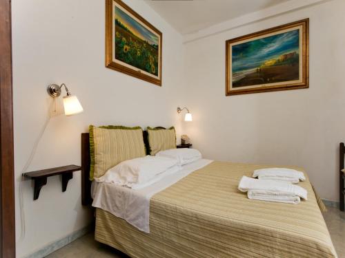 ein Schlafzimmer mit einem Bett und zwei Kissen darauf in der Unterkunft Huge Holiday Home in Marina di Castagneto Carducci near Sea in Donoratico