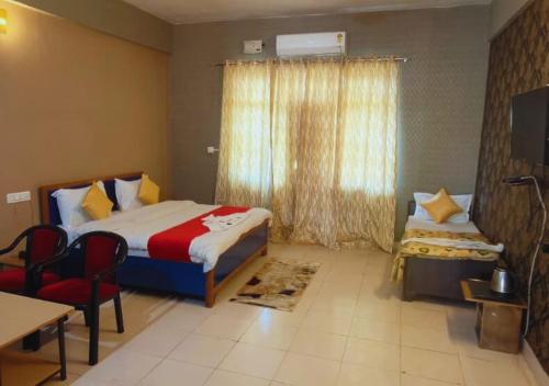 ein Hotelzimmer mit zwei Betten und einem Fenster in der Unterkunft Kanara Hotel in Bhīm Tāl