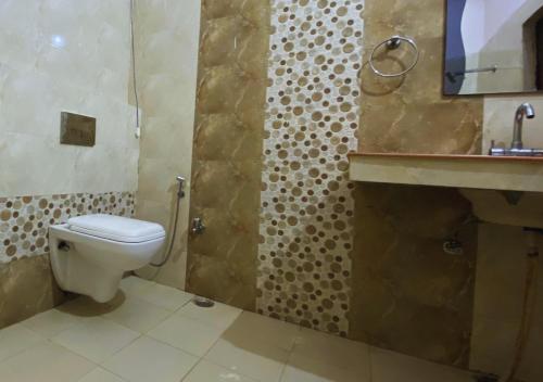 ein Badezimmer mit Toilette und Waschbecken in der Unterkunft Kanara Hotel in Bhīm Tāl