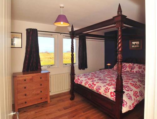 um quarto com uma cama, uma cómoda e uma janela em Beinn Edra apartment em Staffin