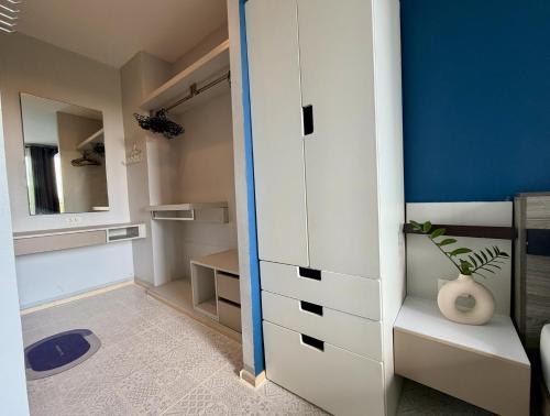 a bedroom with a white cabinet and a mirror at Z cape 1 two two in Ban Thalat Choeng Thale