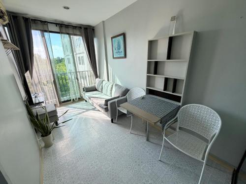 a living room with a table and chairs and a window at Z cape 1 two two in Ban Thalat Choeng Thale