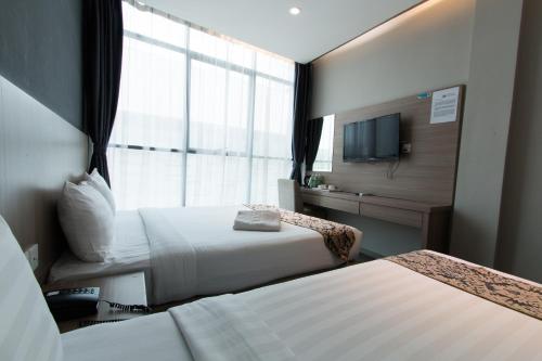 a hotel room with two beds and a window at Hotel 99 Kuala Lumpur City in Kuala Lumpur