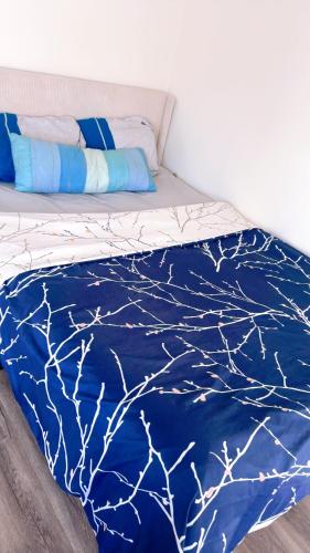 a bed with a blue comforter with branches on it at Pretty bedroom with shared bathroom in Hacienda Heights