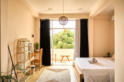 een slaapkamer met een bed en een groot raam bij Casa Banana in Weligama