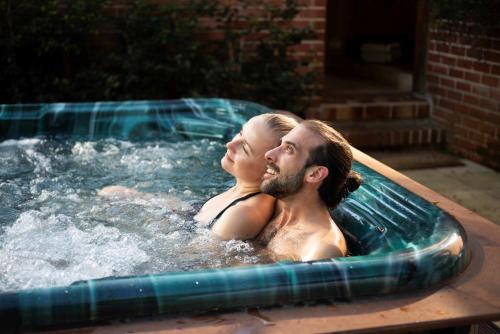 a man and a woman in a hot tub at Celestial Dew Guesthouse in Tyalgum in Tyalgum