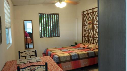 een slaapkamer met twee bedden, een tafel en een raam bij La Casita in Gamboa