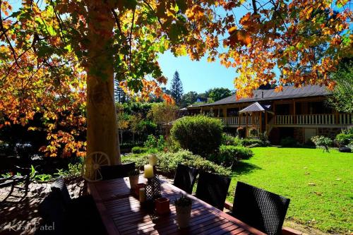 a table and chairs under a tree in a yard at Banksia Cottage in Perth Hills in Perth