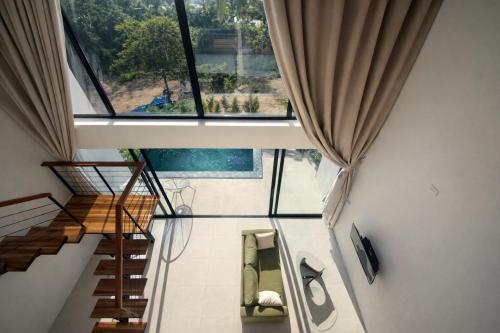 een kamer met een trap en een groot raam bij Sumba Luxury Cottages Pool & Jacuzzi in Ko Pha Ngan