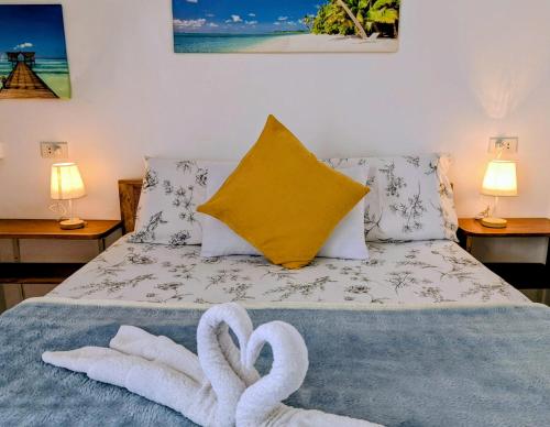 two towels on a bed with two swans on it at Astillo's Guest Houses in Moalboal