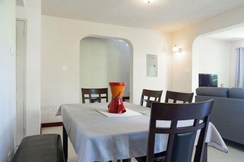 ein Esszimmer mit einem Tisch und einer Vase darauf in der Unterkunft St Silas Condos by ZenBreak in Saint James