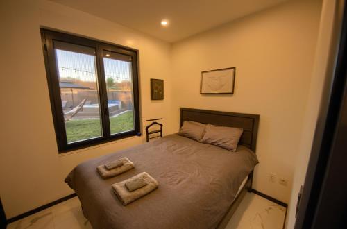 een slaapkamer met een bed met twee handdoeken erop bij House California 