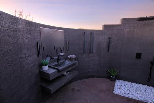 een badkamer met een wastafel en een spiegel bij House California 