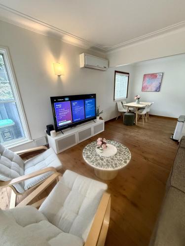 a living room with a couch and a tv at Saltwater Escape in Swansea