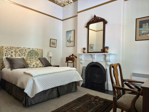 a bedroom with a bed and a mirror and a fireplace at Claremont Oak Estate in Launceston