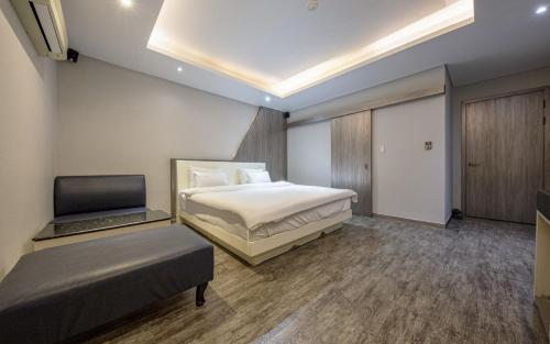 a bedroom with a bed and a laptop in it at Spa Tower Motel in Daejeon