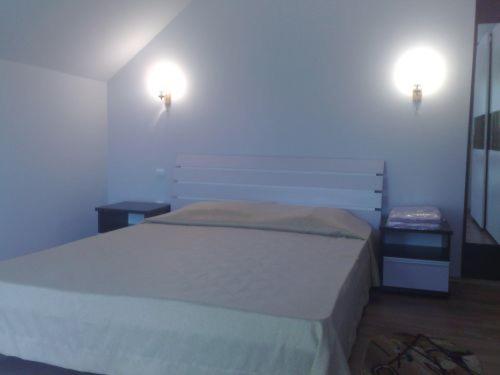a bedroom with a bed and two lights on the wall at Colt de Rai in Covasna