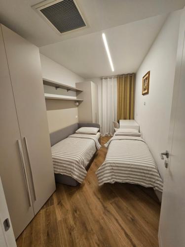 - une rangée de lits dans une chambre dotée de parquet dans l'établissement Teuta, à Nago