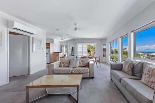 een woonkamer met een bank en een tafel bij Spa Haven 18A in Airlie Beach