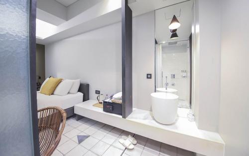 a bathroom with a sink and a bed at BROWN DOT Hotel Dadaepo Beach in Busan