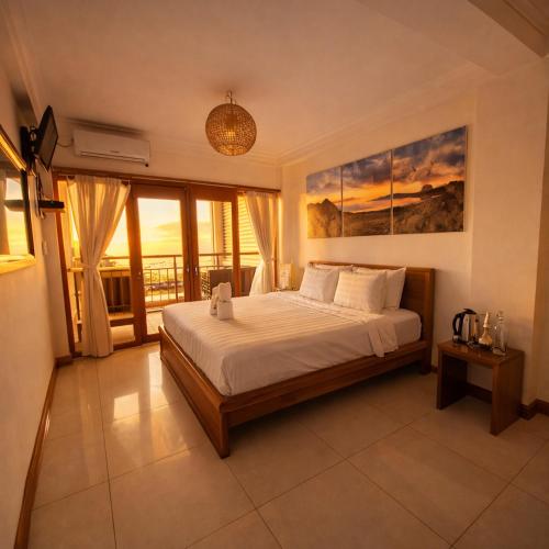 a bedroom with a bed and a large window at The Loft by Smoke House - Central Stay - Stairs Access in Labuan Bajo