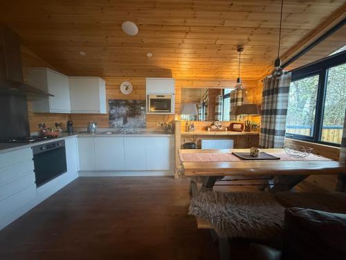 eine Küche mit Holzdecke und Holztisch in der Unterkunft Balquhidder Braes Holiday Park Lodges, mostly with Hot Tubs and pet friendly, EV facilities in Lochearnhead