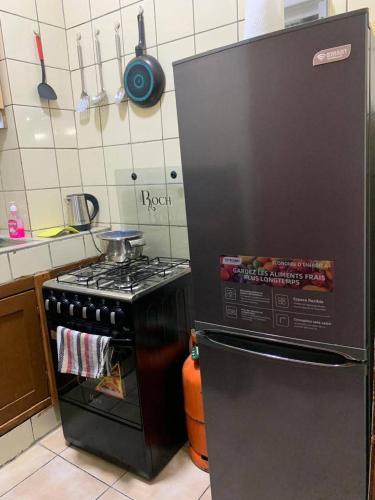 una cucina con fornelli e frigorifero nero di Lumena résidence a Abidjan
