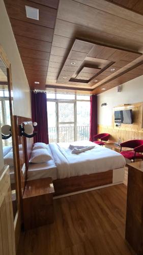 a bedroom with a large bed and a large window at Aagaman Woods Homestay in Shimla