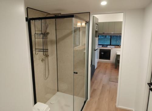 a shower with a glass door in a bathroom at The Glan Devon Tiny Retreat in Glan Devon